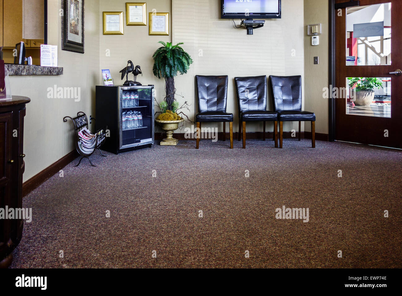Eine Arztpraxis Wartezimmer mit Atrium auf der anderen Seite der Tür, den Check in Schalter zeigen. Oklahoma, USA. Stockfoto