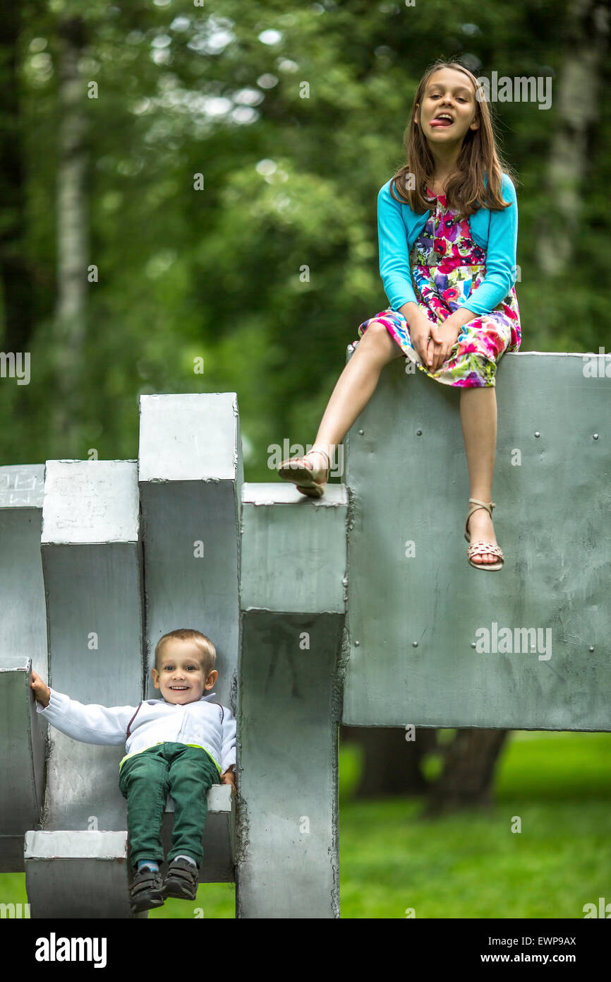 Mädchen mit ihren kleinen Bruder auf dem Spielplatz im City Park. Stockfoto