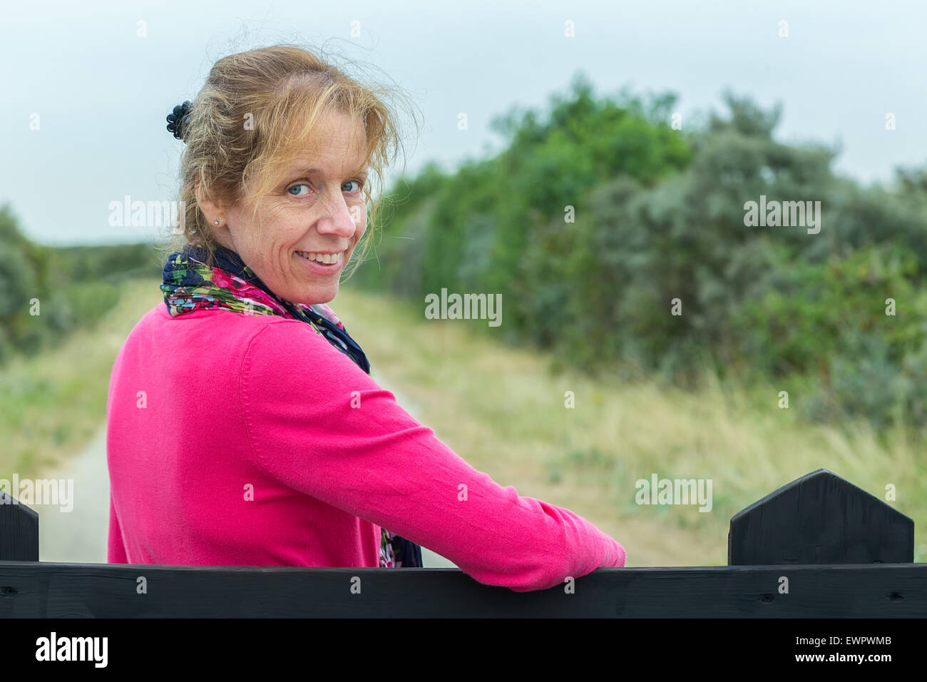 Porträt des mittleren gealterten kaukasischen Frau am Zaun, Wandern in der Natur Stockfoto