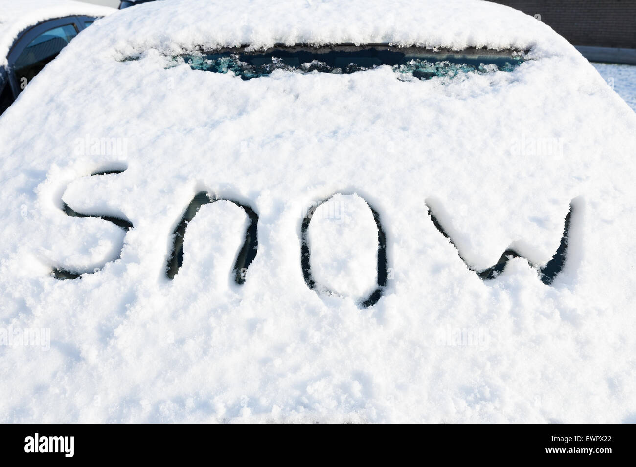 Wort Schnee auf der Windschutzscheibe des Autos im Wintersaison Stockfoto