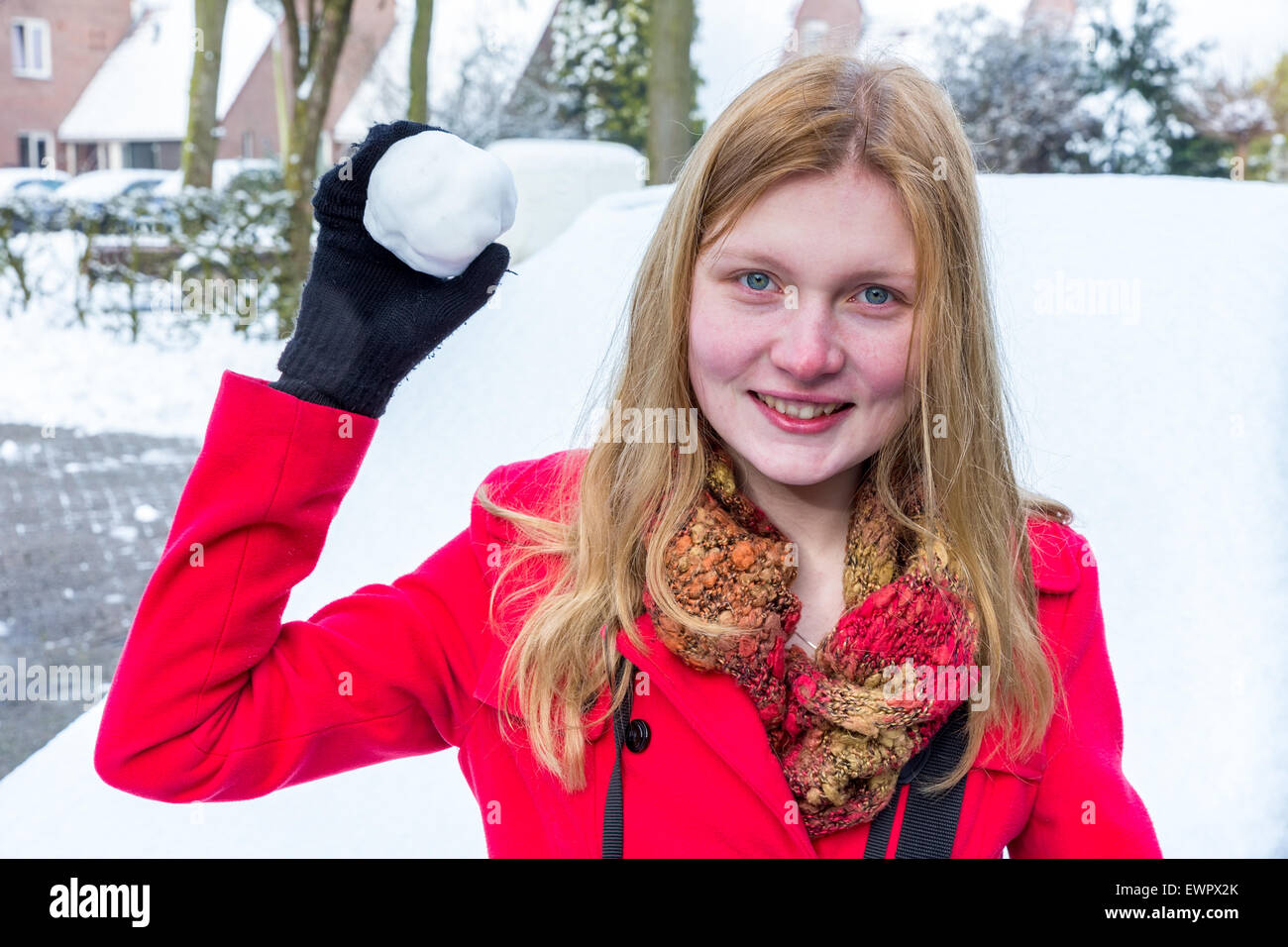 Kaukasische Mädchen gekleidet in rot halten Schneeball werfen im winter Stockfoto