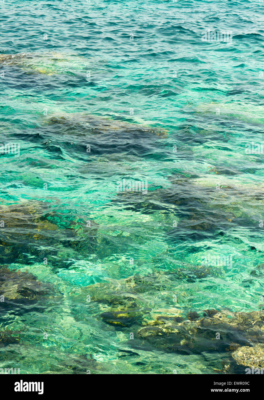 klarem Wasser plätschern, marine Steinen und Sonneneinstrahlung Blendung. Meer unten Hintergrund Stockfoto