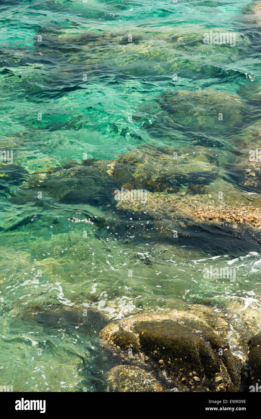 transparentes Wasser plätschern, marine Felsen und Sonneneinstrahlung Blendung. Meeresboden Hintergrund Stockfoto