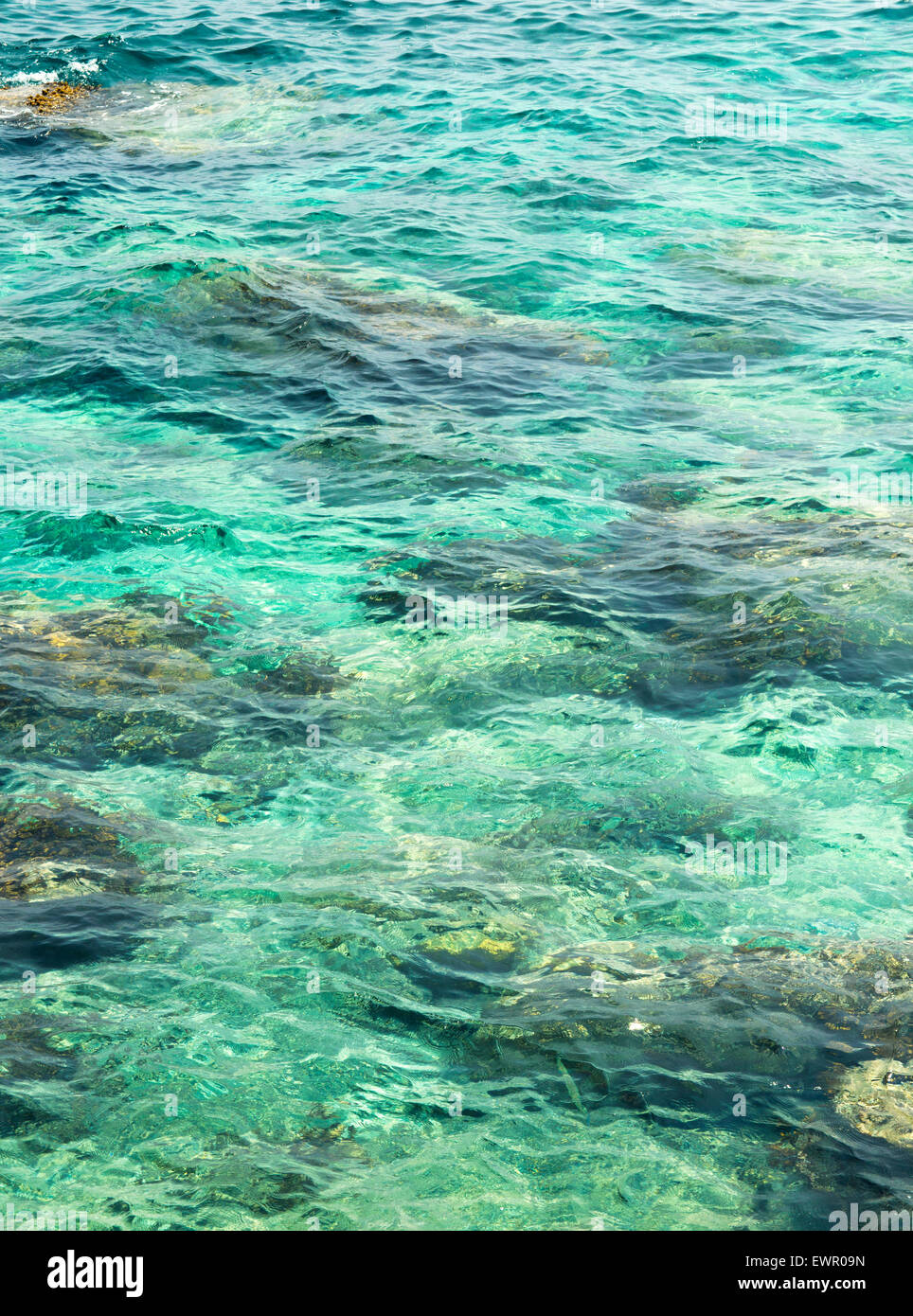 transparentes Wasser plätschern, marine Steinen und Sonneneinstrahlung Blendung. Meeresboden Tapete Stockfoto