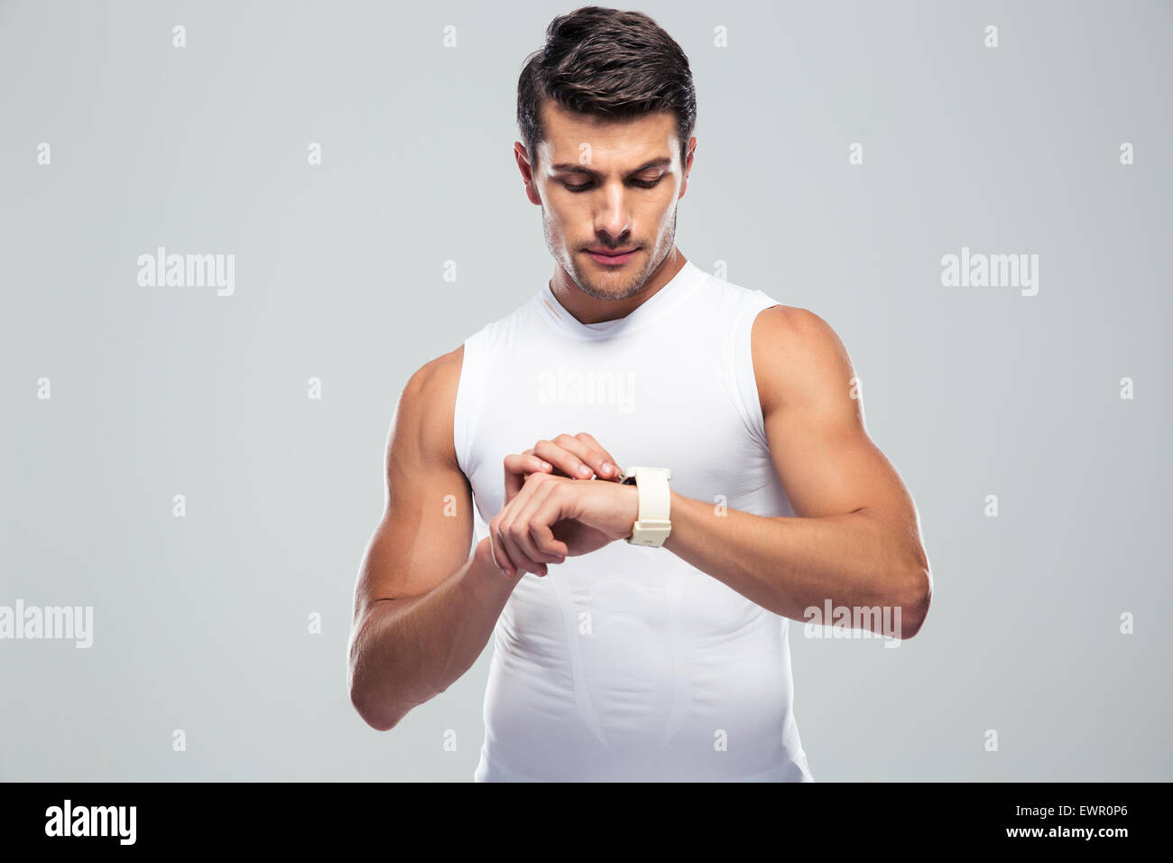 Gut aussehend Fitness Mann mit smart-Watch über grauen Hintergrund Stockfoto