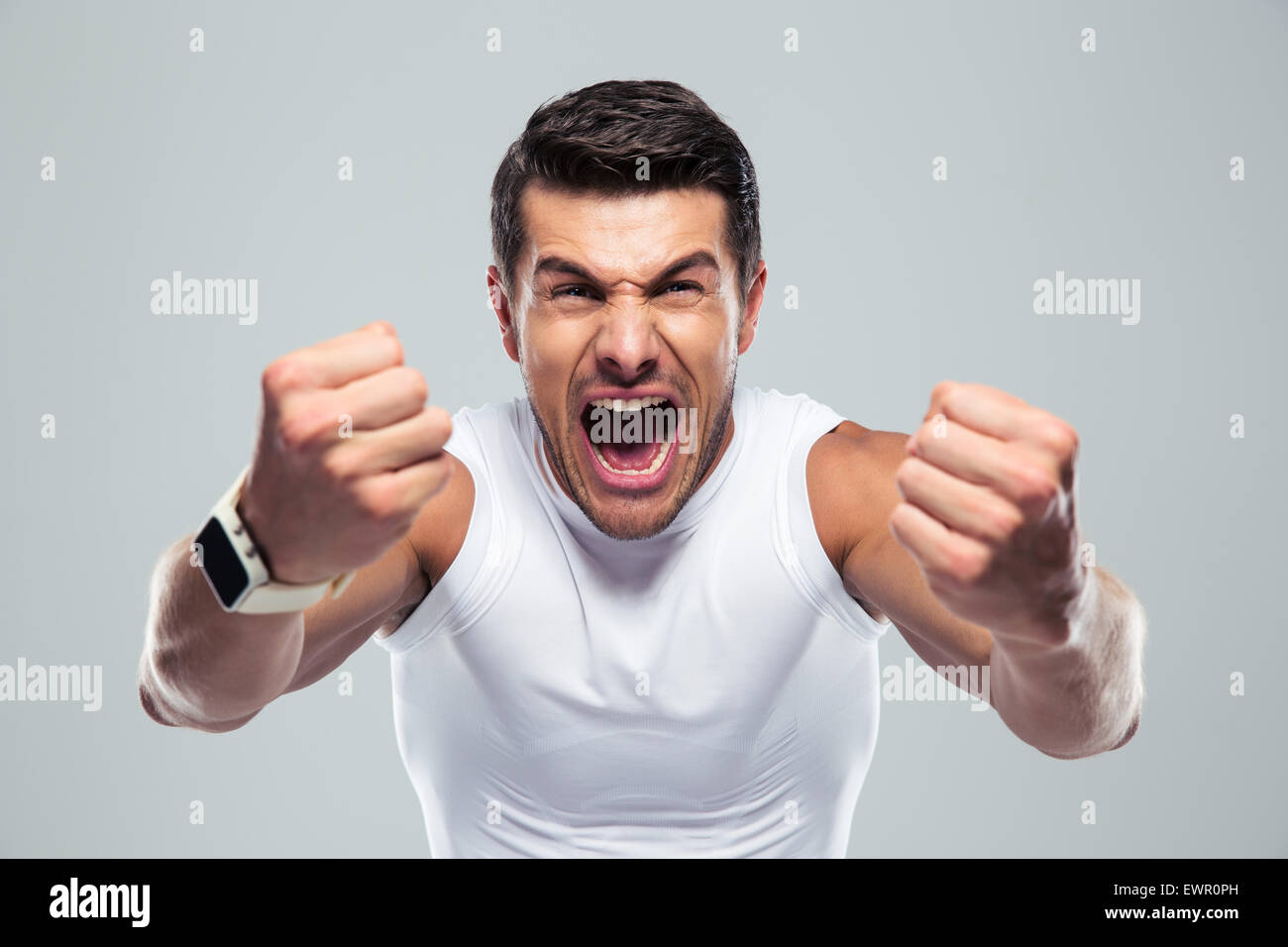 Aufgeregt Fitness Mann anschreien Kamera über grauen Hintergrund Stockfoto
