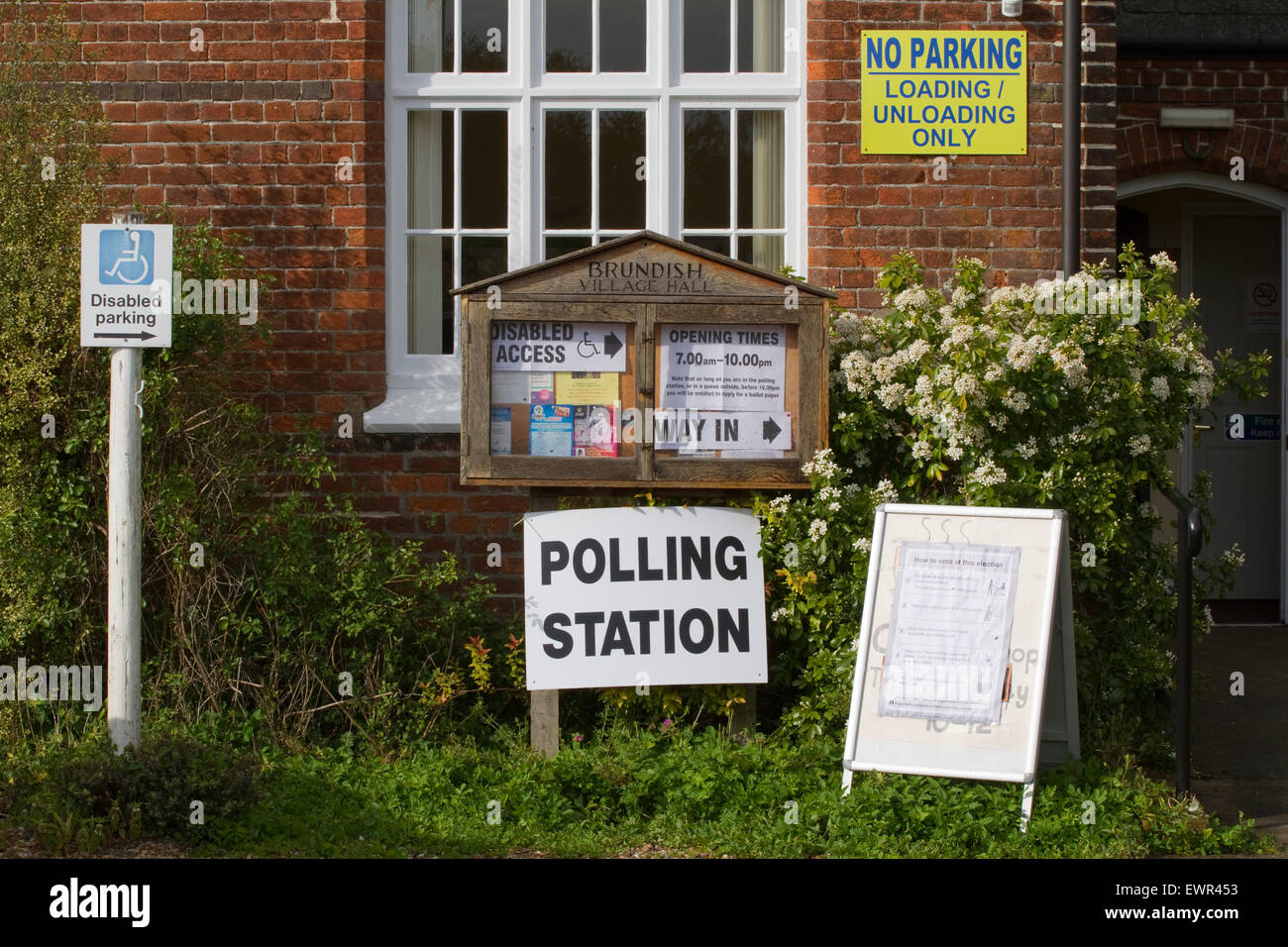 Eine Fülle von Zeichen außerhalb einer Suffolk Dorfhalle als ein Wahllokal für allgemeine Wahlen verwendet wird Stockfoto