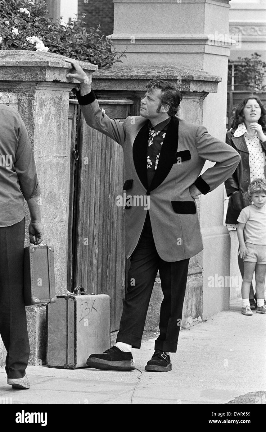 Schauspieler Oliver Reed in Teddy Boy Kleidung während einer Pause in der Pop-Oper 'Tommy' von Regisseur Ken Russell Dreharbeiten gekleidet. 13. Juni 1974. Stockfoto