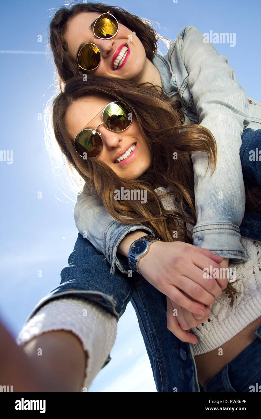 Zwei Mädchen mit Sonnenbrille fotografieren mit einem smartphone Stockfoto