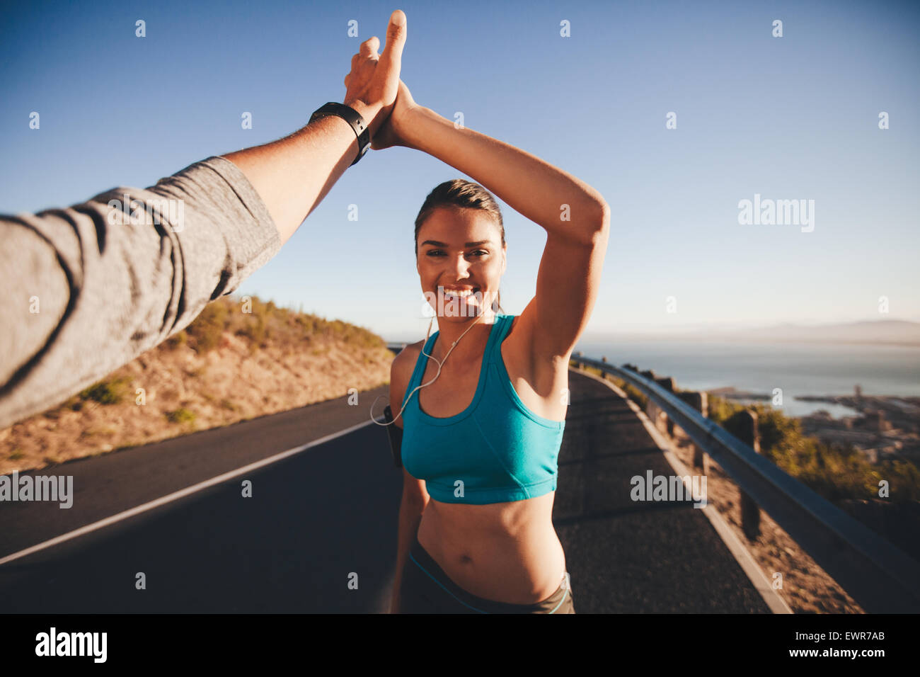 First-Person-Ansicht von Mann und Frau ein high Five zu tun. Glückliche junge Frau geben hohe fünf man nach outdoor-Training. Stockfoto
