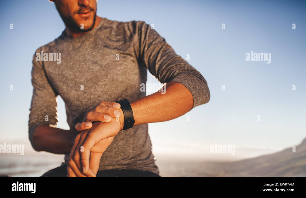 Männlicher Athlet Überprüfung Zeit während des outdoor-Training. Junge Läufer überprüfen der Zeit auf seine Sport-swatch Stockfoto