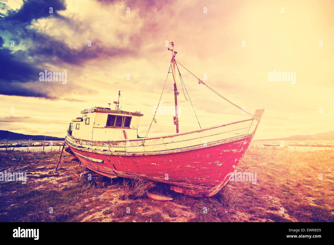 Vintage getönten altes Schiff an einem Strand bei dramatischen Sonnenuntergang. Stockfoto