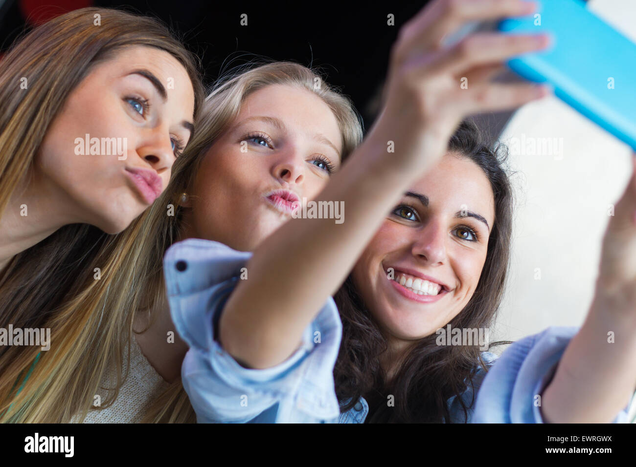 Indoor-Porträt von drei Freunden fotografieren mit einem smartphone Stockfoto