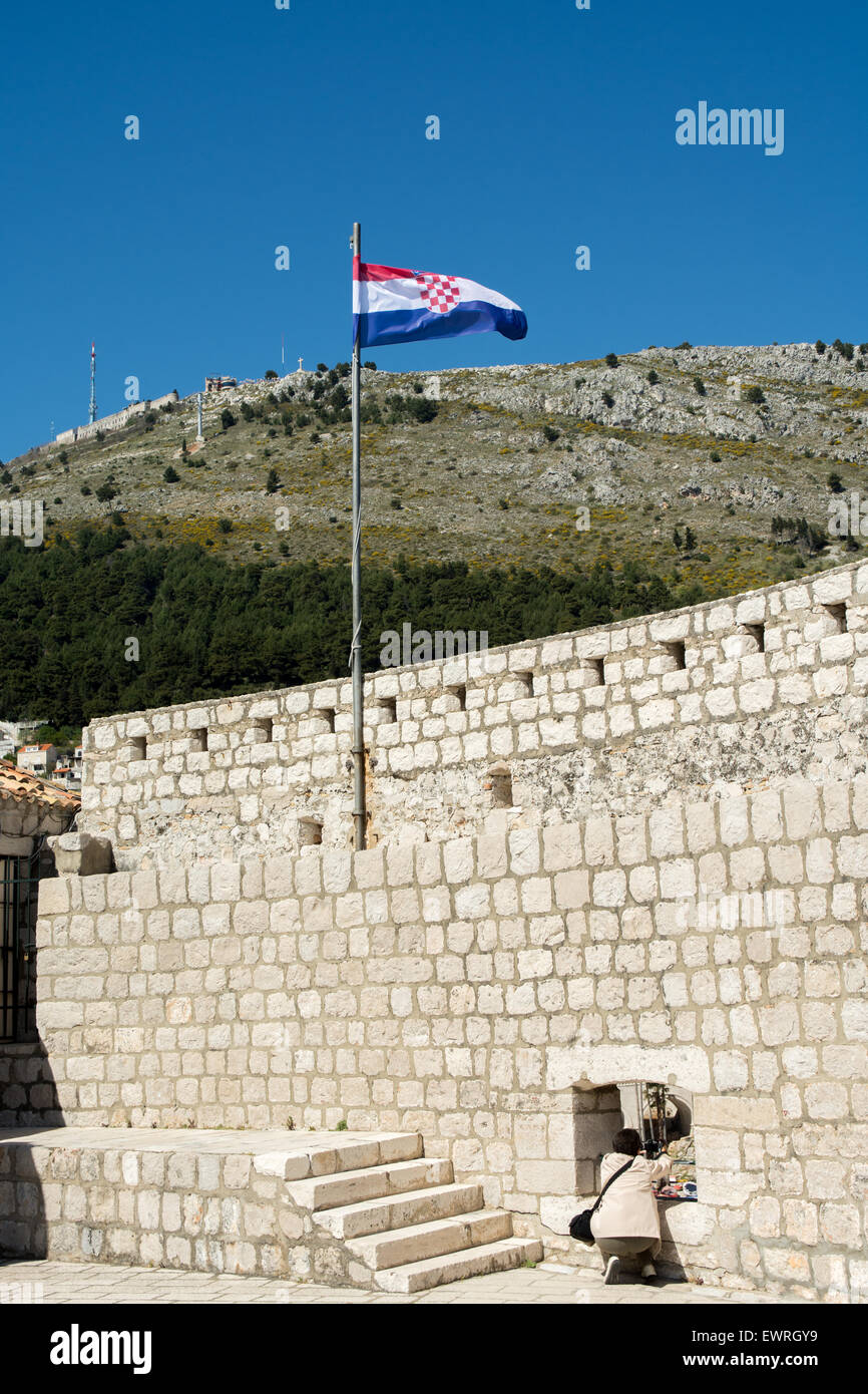 kroatische Flagge über dem alten Stadtmauer mit Srdj Hügel im Hintergrund, Dubrovnik, Kroatien Stockfoto