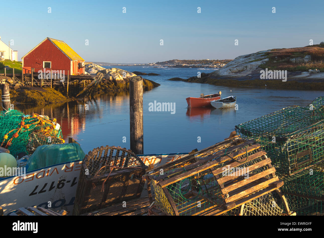 Nova Scotia Peggys Cove, Kanada Fischerdorf mit Lobster Boote und Hummer Töpfe. Blauer Himmel und farbenfrohen Gebäuden. Stockfoto