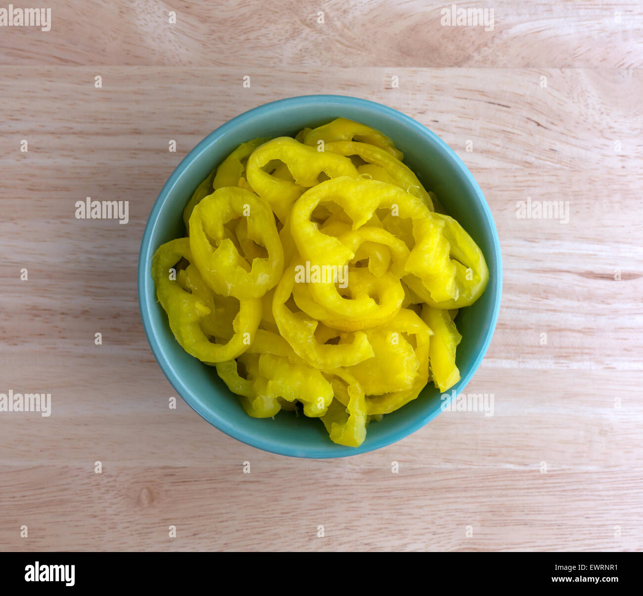 Draufsicht auf eine kleine Schüssel voller Crinkle Banane Paprika auf einem Holztisch Top geschnitten. Stockfoto