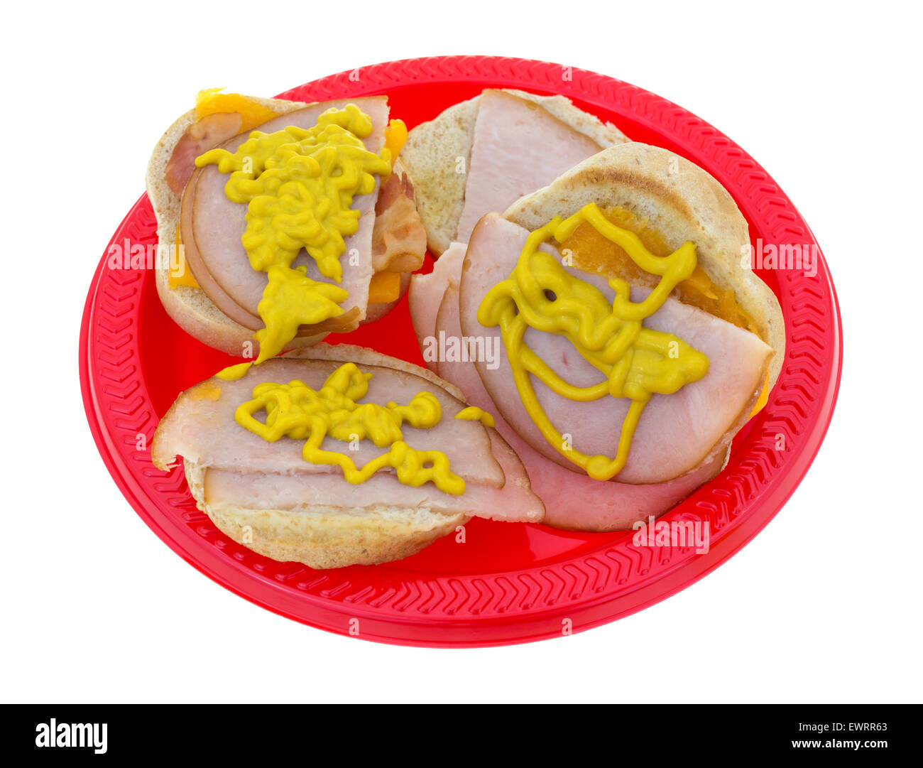 Zwei kleine Truthahn-Sandwiches mit Speck und Cheddar-Käse und Senf auf einem roten Picknick Teller. Stockfoto
