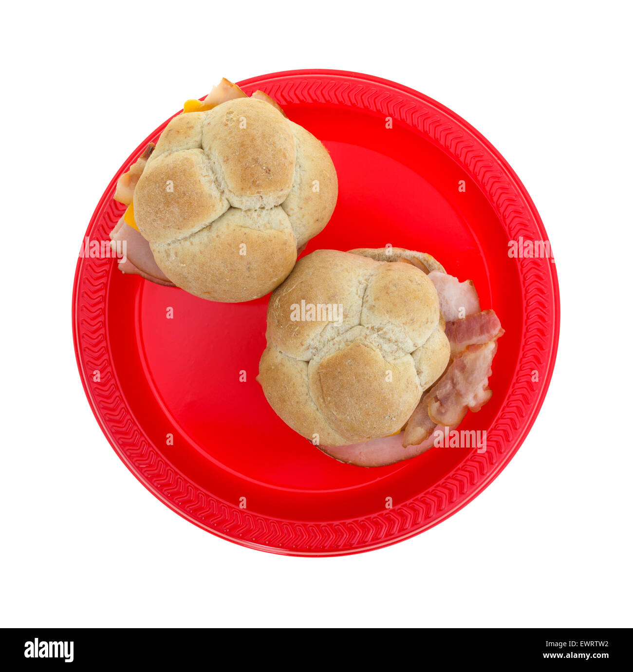 Draufsicht der zwei kleinen Truthahn-Sandwiches mit Speck und Cheddar Käse auf Weizen Brötchen auf einem roten Picknick Teller. Stockfoto