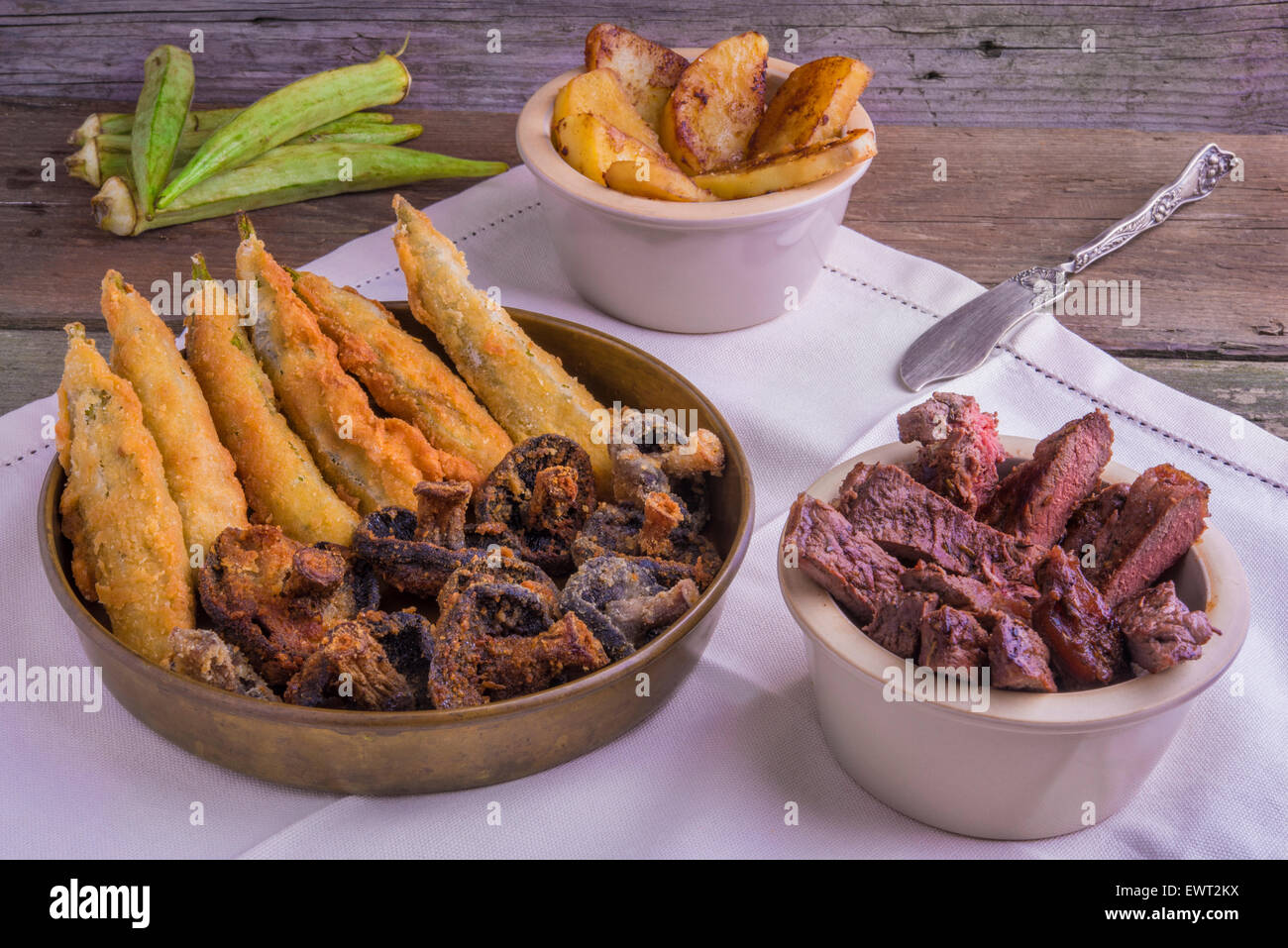 Cajun Stil gegrilltes Entrecote mit tiefen gebratene Okraschoten, Pilzen und Glasierte Süßkartoffeln Stockfoto