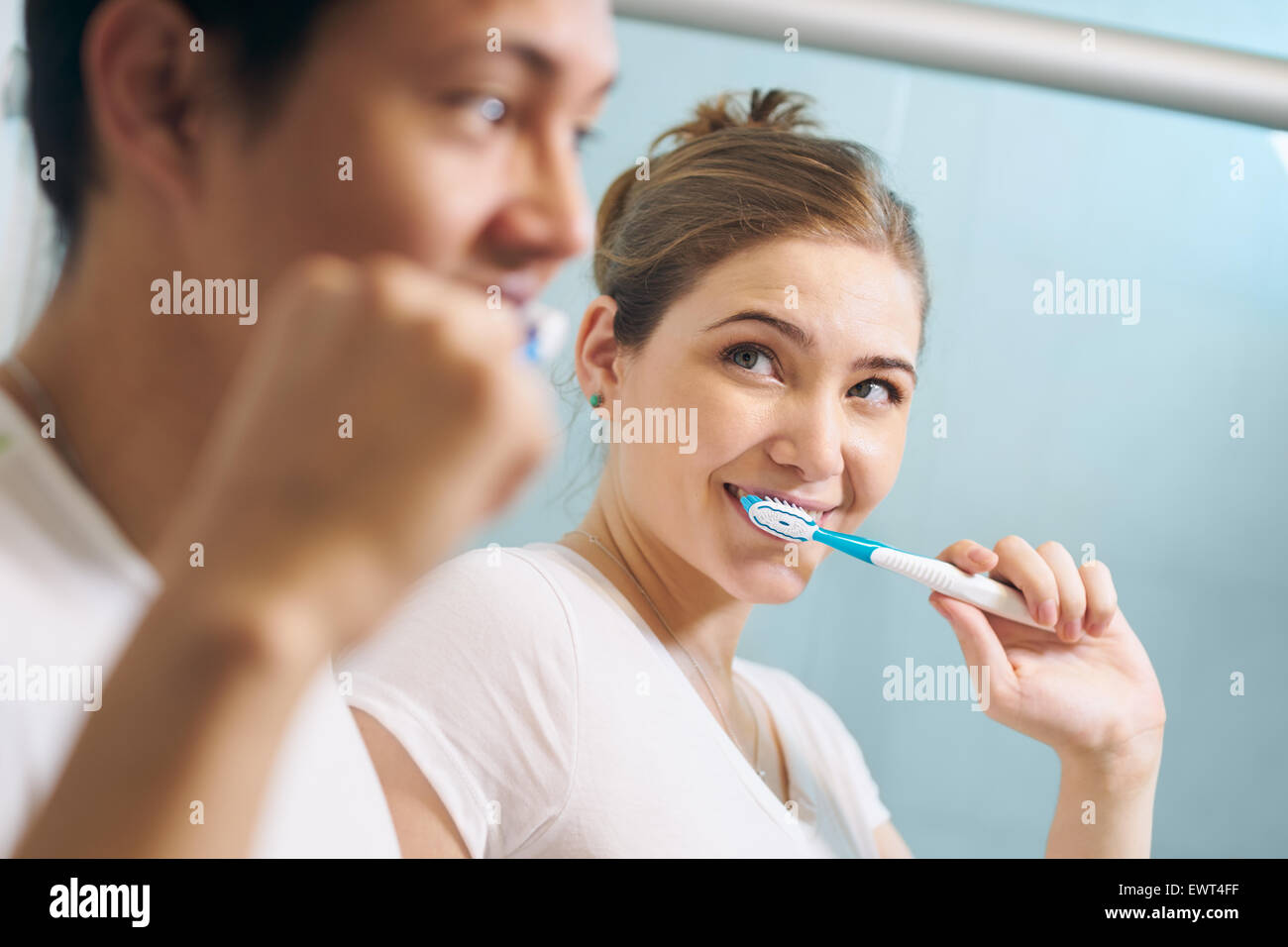 Junges Paar Zusammenleben, waschen Zähne im Bad am Morgen. Die Frau schaut gerne an ihren Freund. Konzept der neu Stockfoto