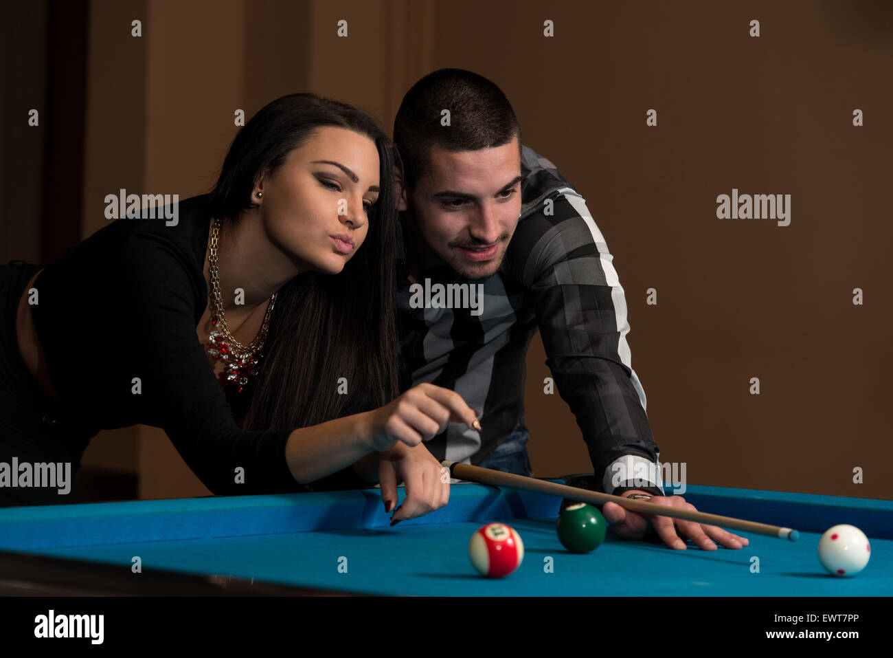 Kaukasischen Jüngling beraten auf das Schießen Pool Kugel beim Billard spielen Stockfoto