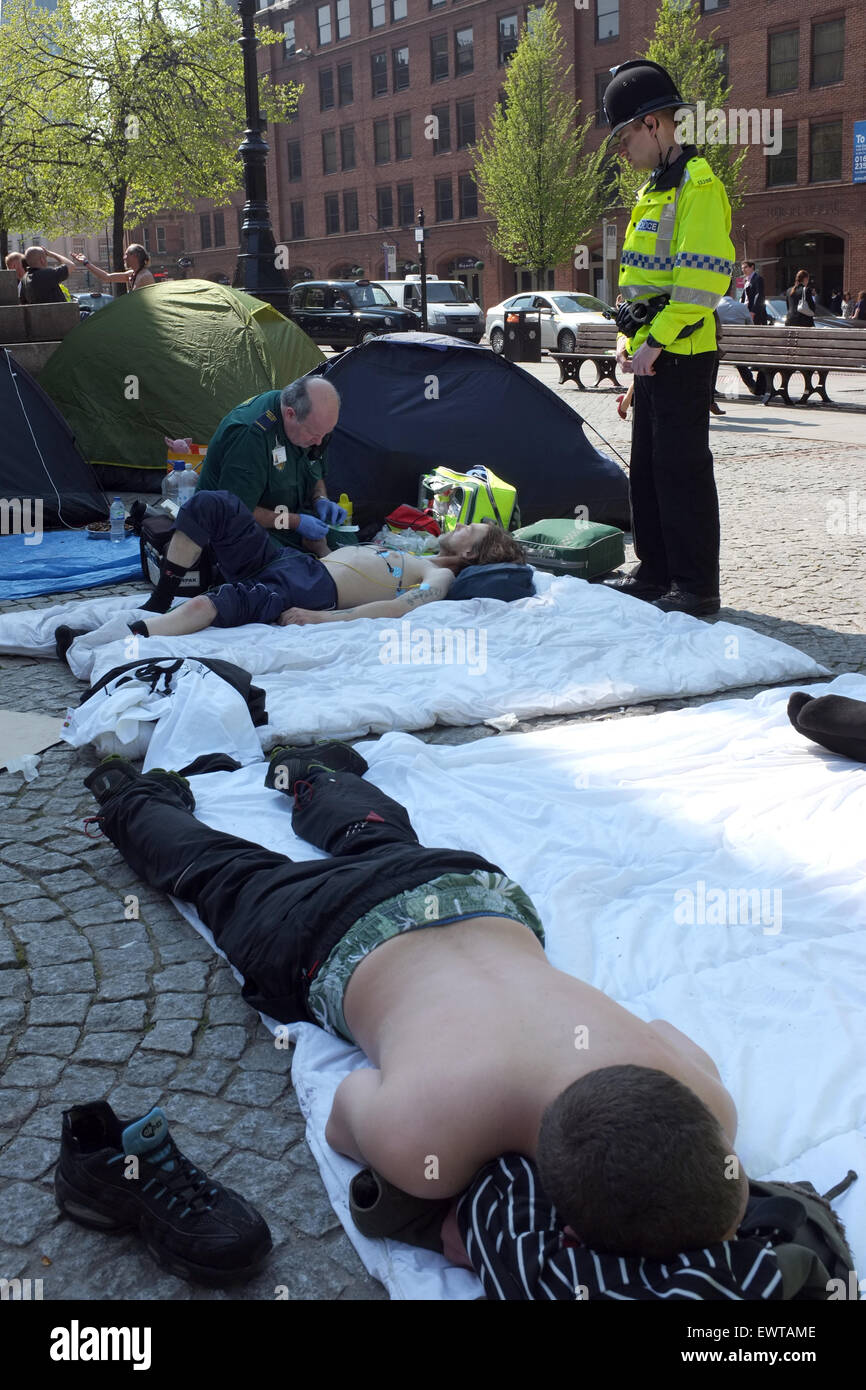 Ein Sanitäter und ein Polizist hilft obdachlosen Demonstranten Camping in Albert Square im Stadtzentrum von Manchester England England Stockfoto