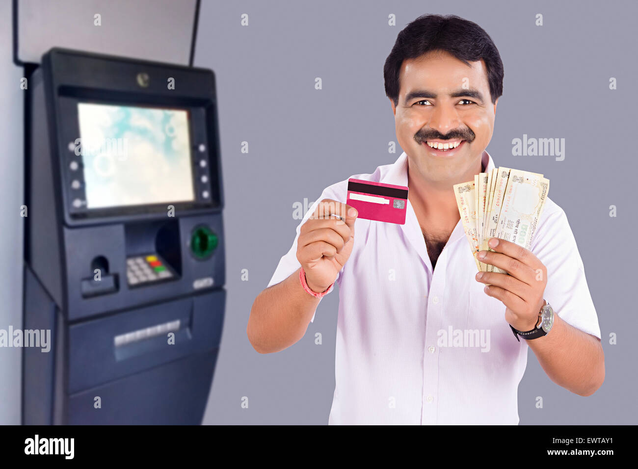1 indischer Mann ATM Maschinen Kreditkarte und Geld zeigen Stockfoto