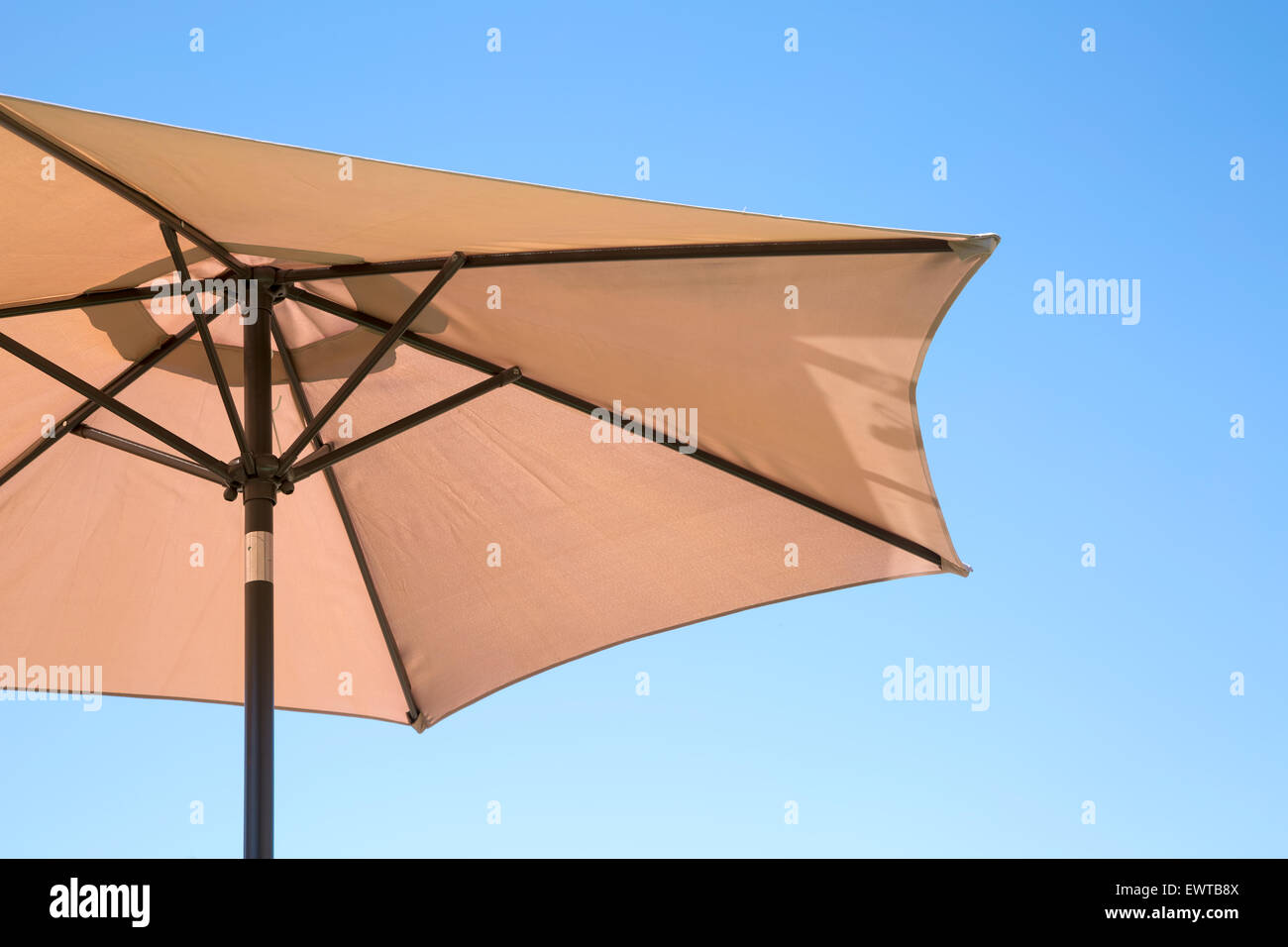 Beige Sonnenschirm auf einem klaren blauen Himmel Stockfoto