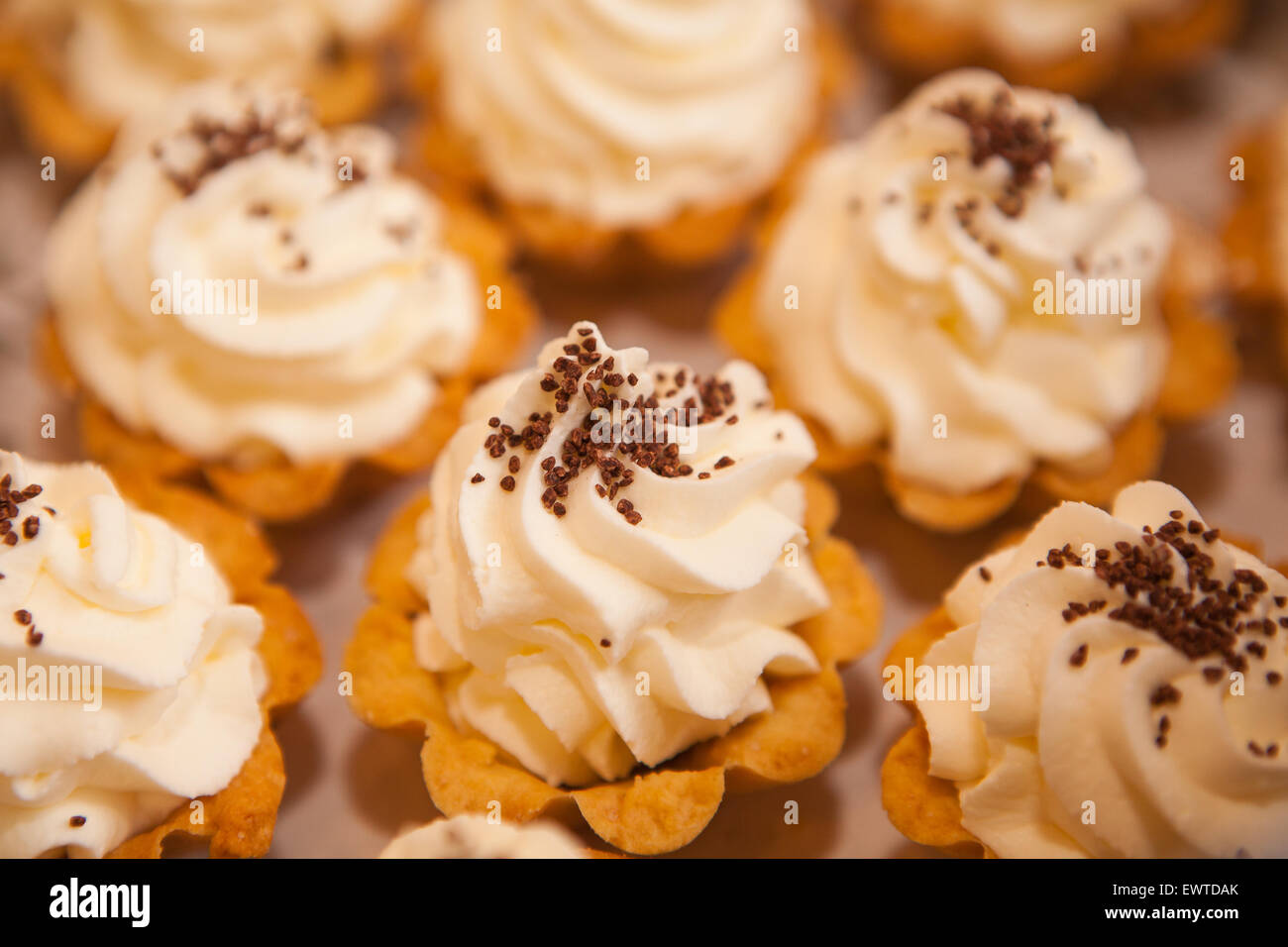 Herb lässt Mini Kuchen mit gesichert Schlagsahne weißen weichen mit chocolate Chips in kleinen Körben Stockfoto