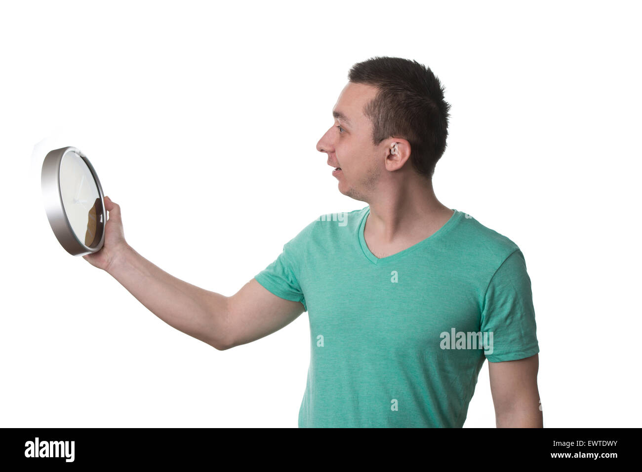 Mann trägt ein grünes T-shirt und er hält eine Uhr - Over White Background, isoliert Stockfoto