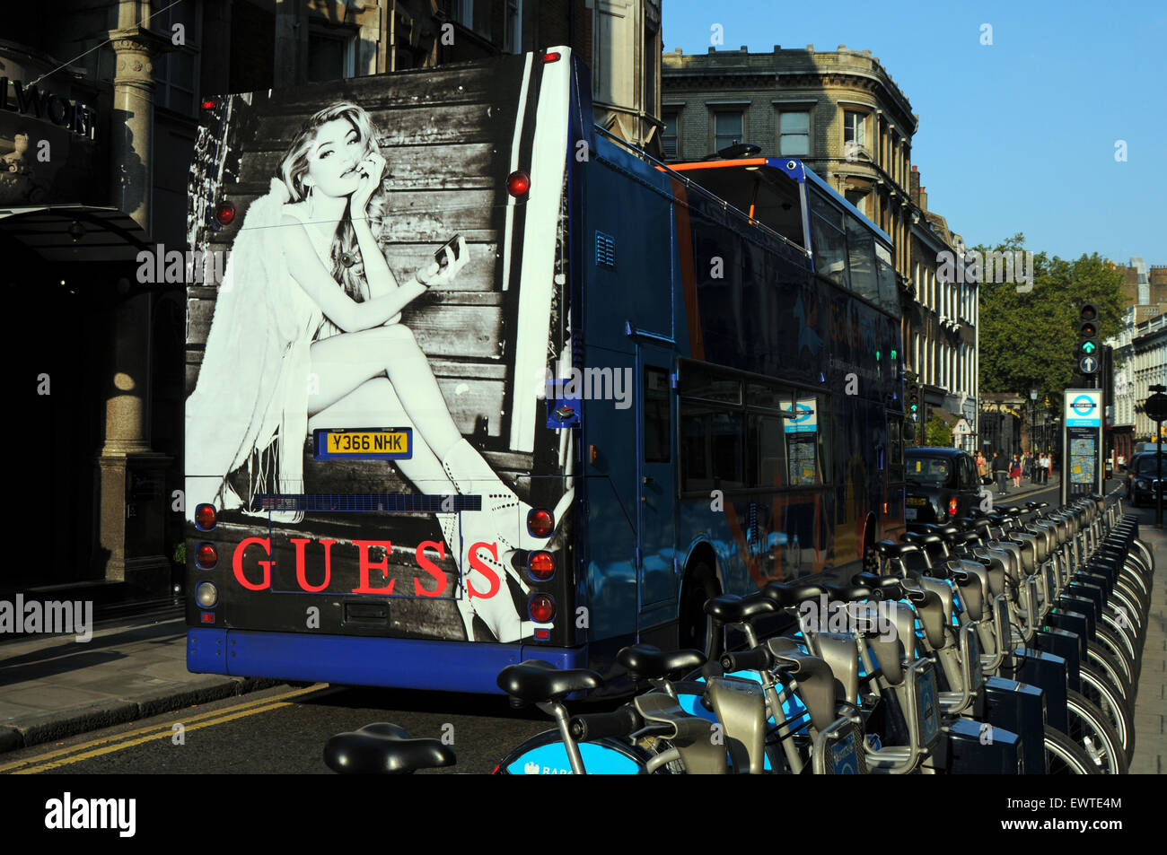 London, UK, 22.09.2014, Bus mit Guess Anzeige Pässe Reihe von Barclays Boris Bikes. Stockfoto