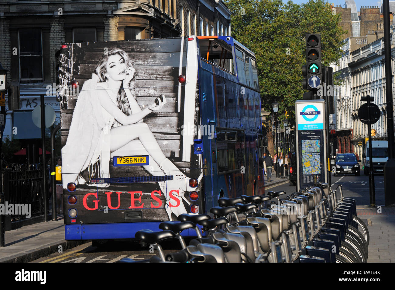 London, UK, 22.09.2014, Bus mit Guess Anzeige Pässe Reihe von Barclays Boris Bikes. Stockfoto