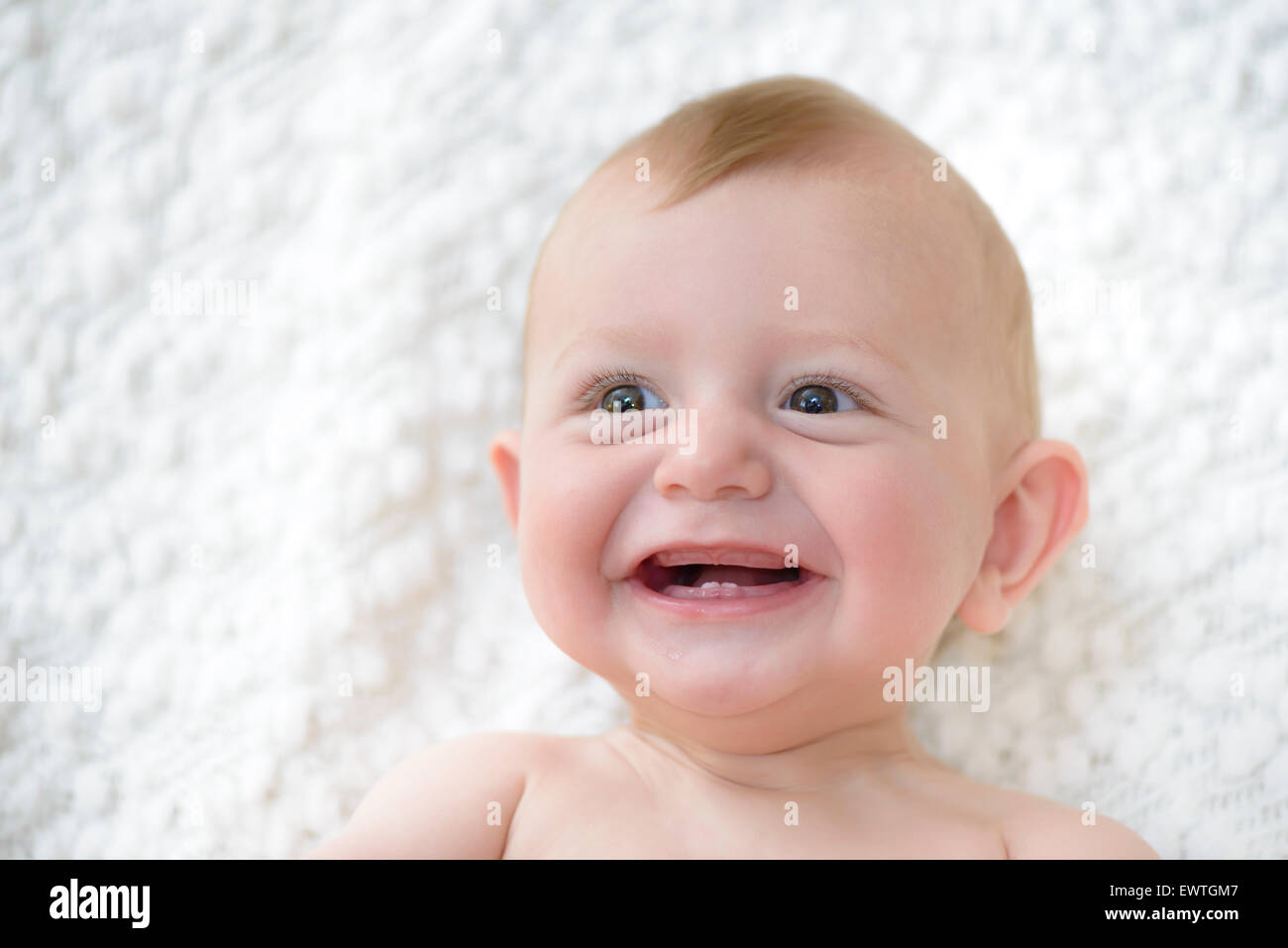 Niedliche Baby lacht und zeigt seine ersten Zähne Stockfoto