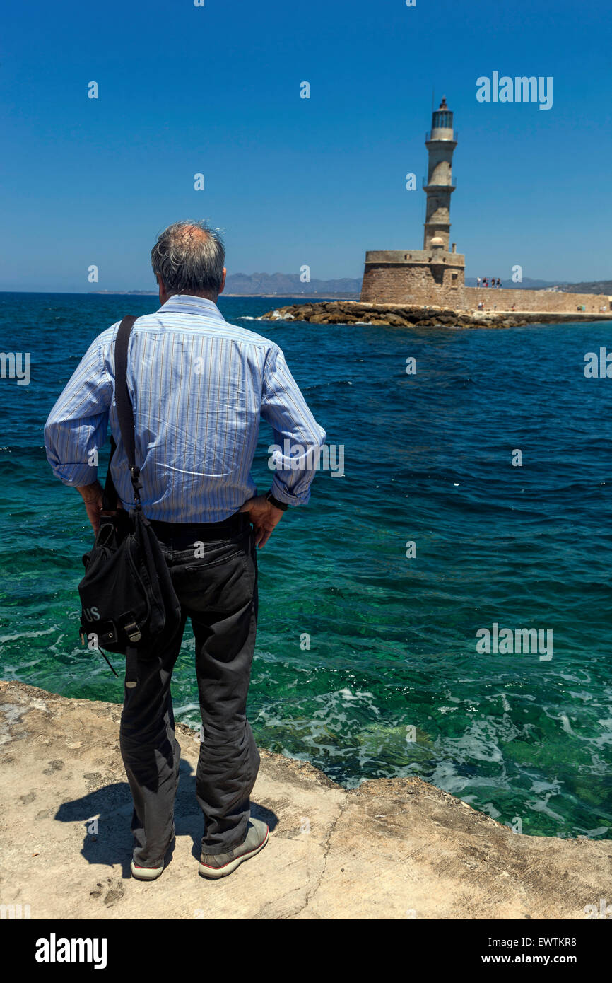 Chania Lighthouse, alter venezianischer Hafen Chania Kreta Griechenland Europa ein erwachsener Mann Senior am Wasser Blick auf den Leuchtturm Stockfoto