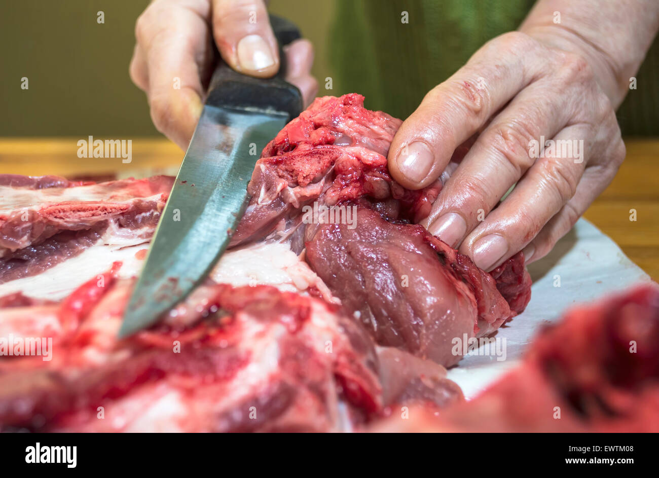 Hände von einem Metzger schneiden Scheiben von rohem Fleisch. Selektiven Fokus Stockfoto