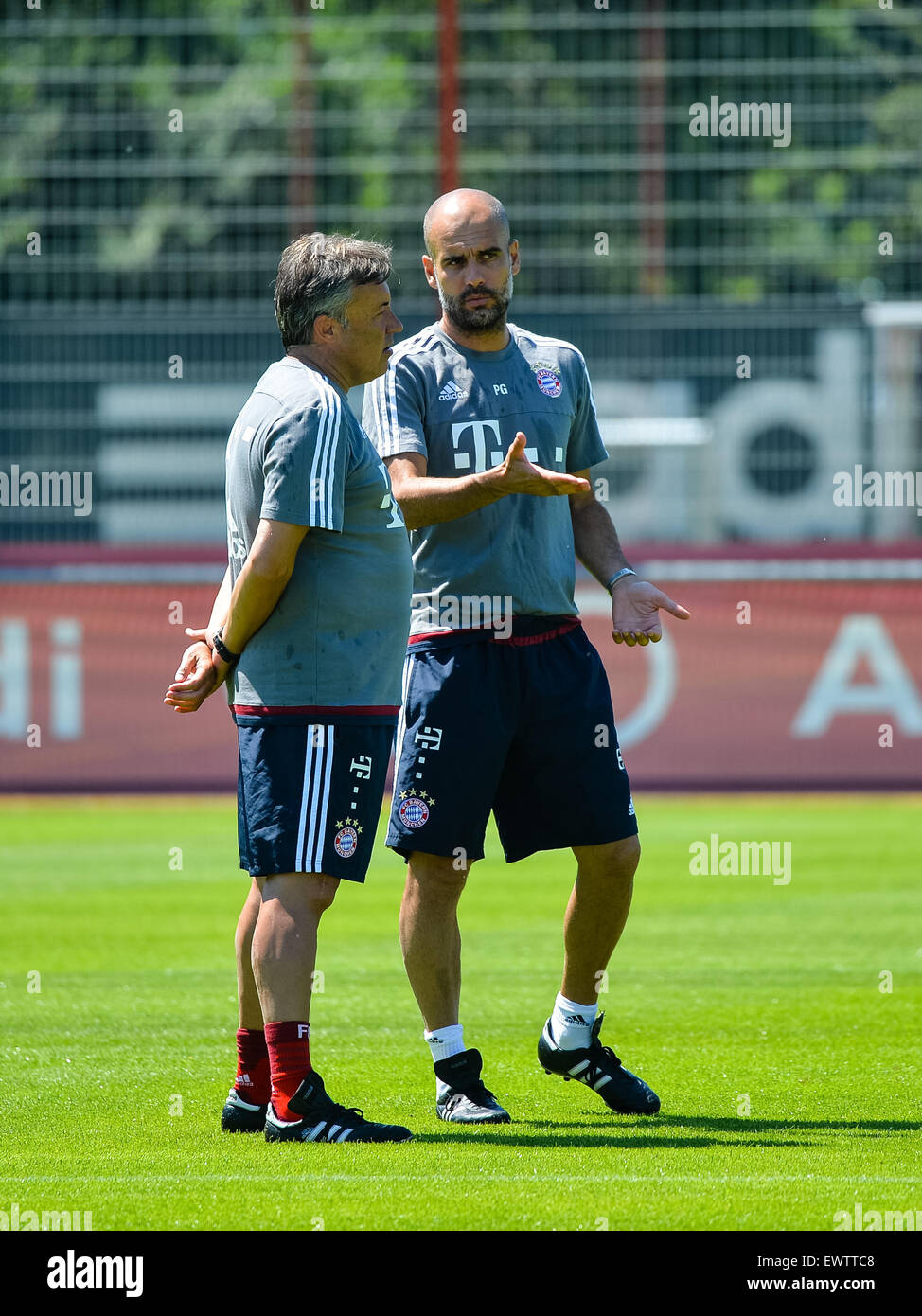 München, Deutschland. 1. Juli 2015. Münchens Trainer Pep Guardiola (R) spricht mit seinem Assistenten Domenec Torrent beim Kick-off Training der deutschen Fußball-Bundesliga-Fußball-Club FC Bayern München in München, 1. Juli 2015. Foto: MATTHIAS MERZ/Dpa/Alamy Live News Stockfoto