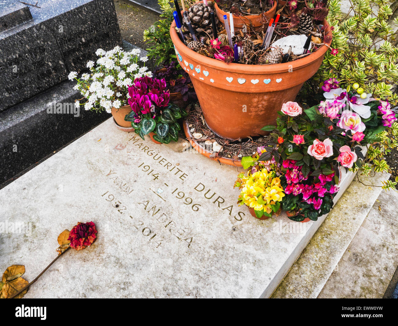 Cimetière du Montparnasse, Paris Montparnasse Friedhof. Berühmte Schriftsteller Grab, Marguerire Duras, Blumen & Stifte durch Ventilatoren links Stockfoto