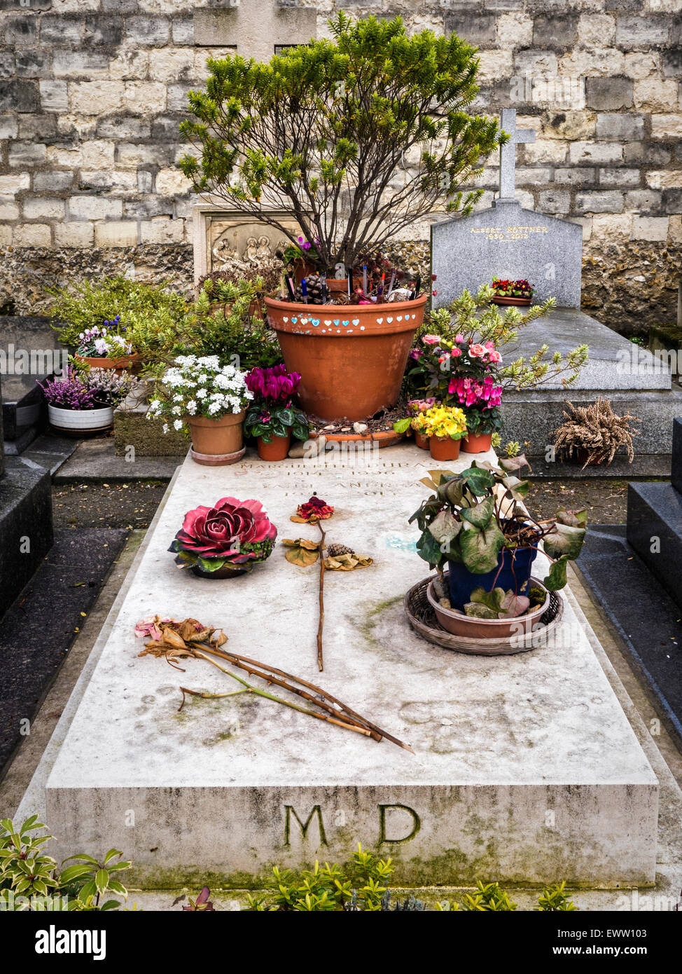 Cimetière du Montparnasse, Paris Montparnasse Friedhof. Berühmte Schriftsteller Grab, Marguerire Duras, Blumen & Stifte durch Ventilatoren links Stockfoto