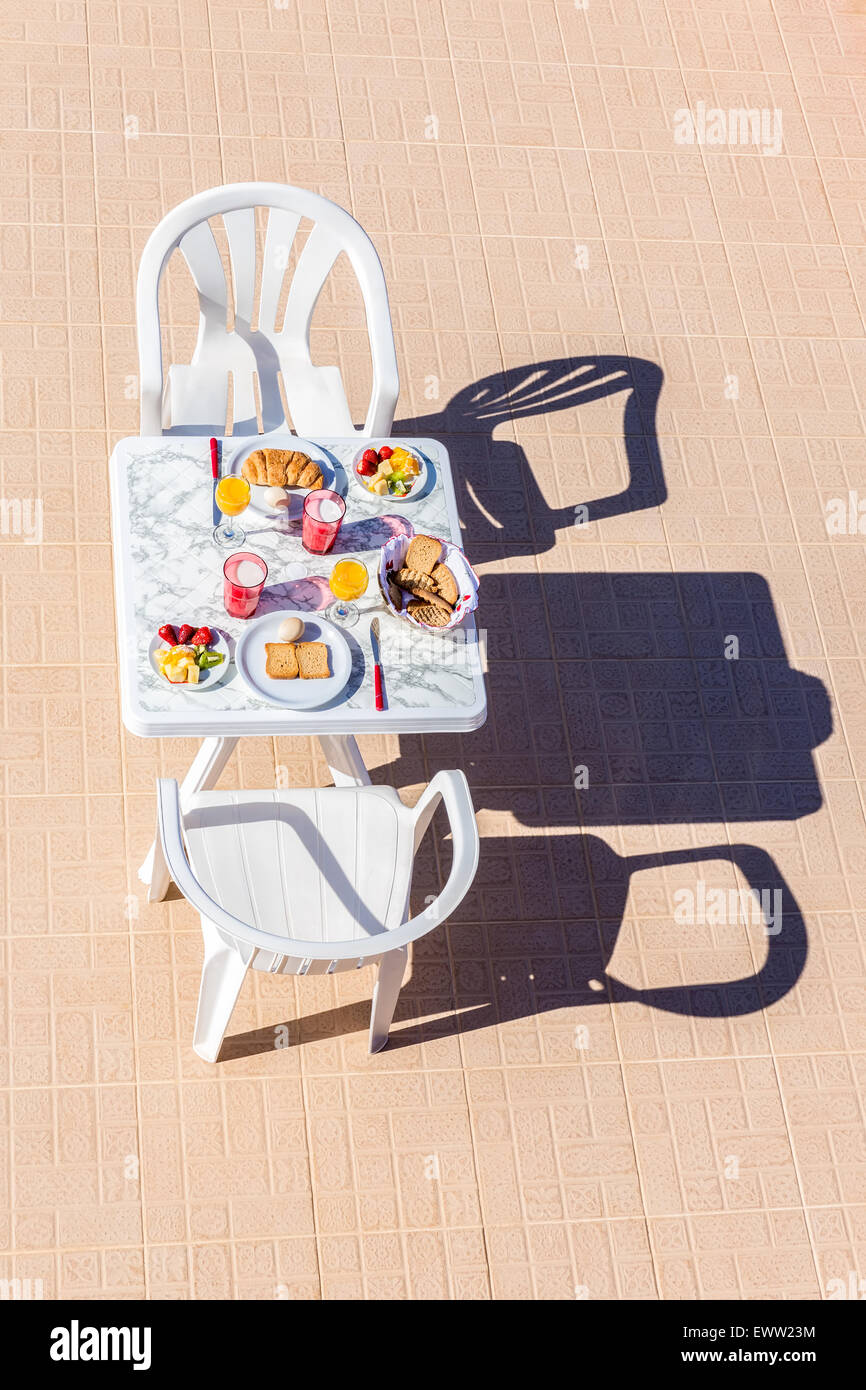 Lebensmittel für das Frühstück am Tisch mit zwei Stühlen auf der Terrasse Stockfoto