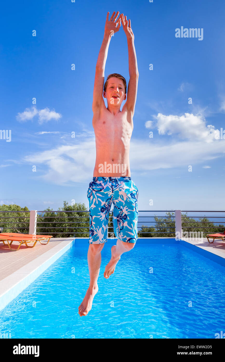 Europäische Teenager springen hoch über dem blauen Swimmingpool Stockfoto