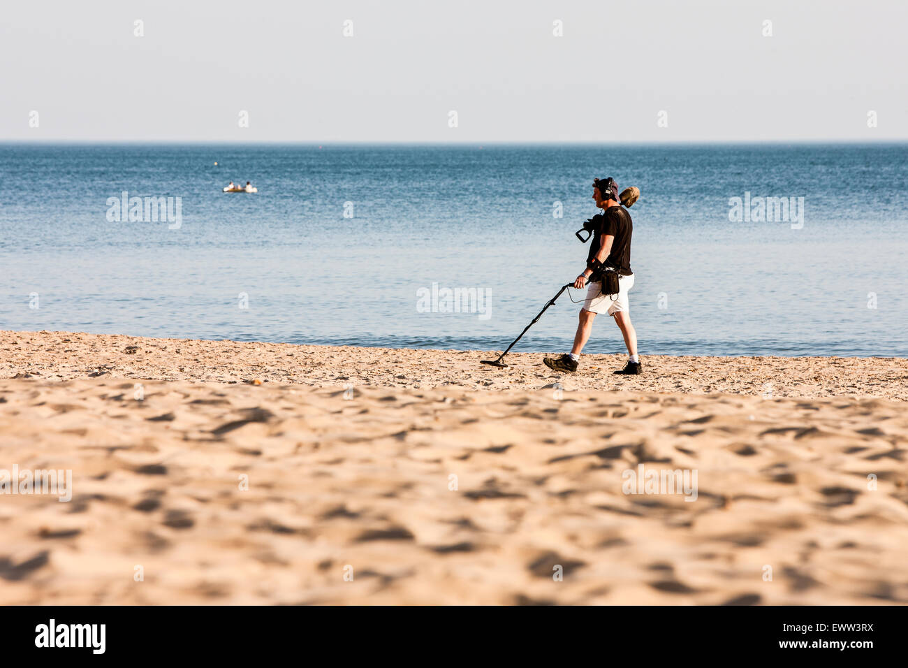 An einem sonnigen Frühlingstag, ein Detectorist mit Metalldetektor nach den meisten Touristen/Urlauber verlassen haben Strand auf der Suche nach verlorenen Gegenständen/Schatz Stockfoto