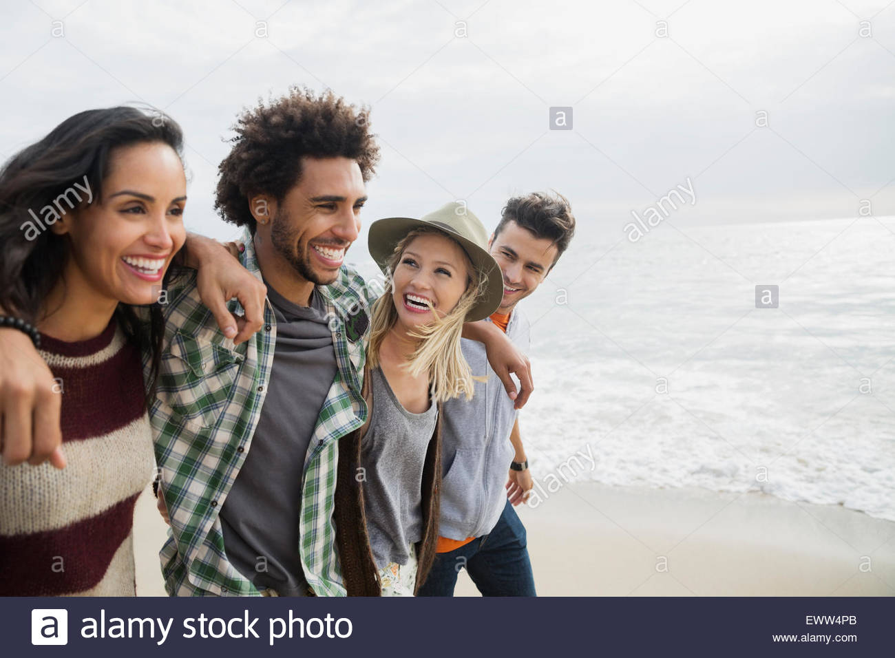 Lächelnden Freunde gehen in einer Reihe am Strand Stockfoto