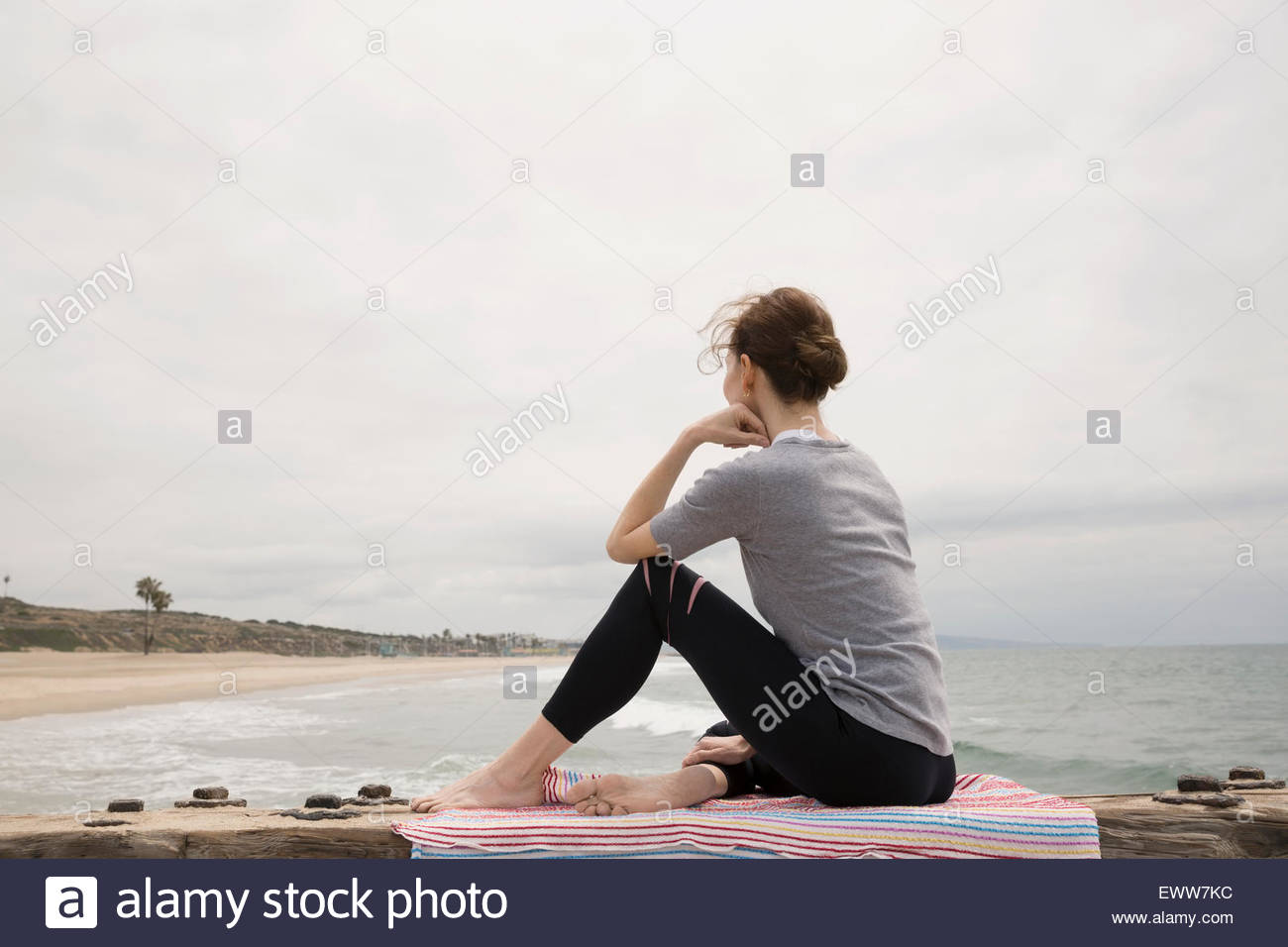 Frau sitzt am Strand Decke betrachten Stockfoto