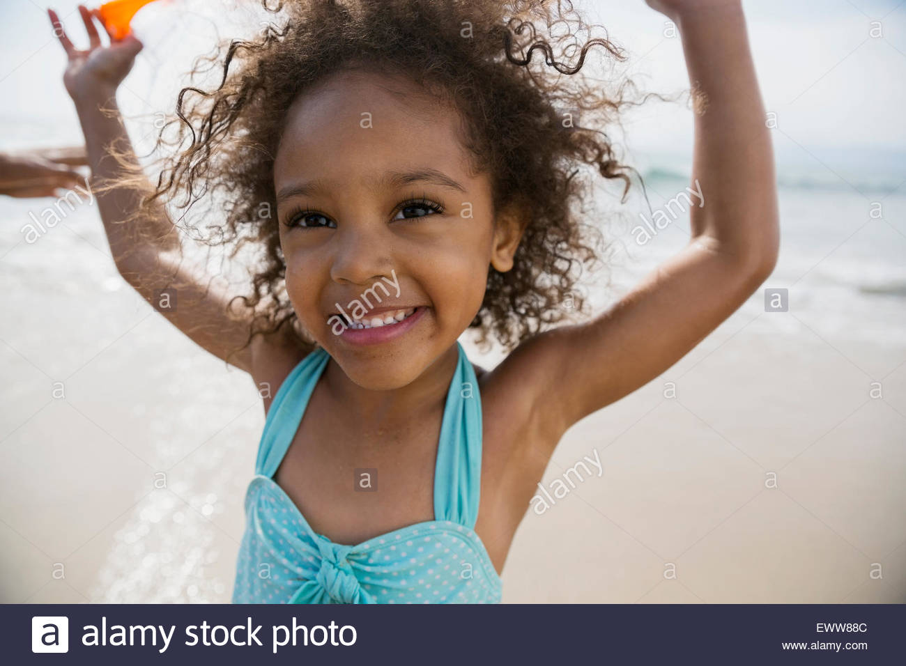 Porträt-Mädchen mit Armen am Strand Stockfoto