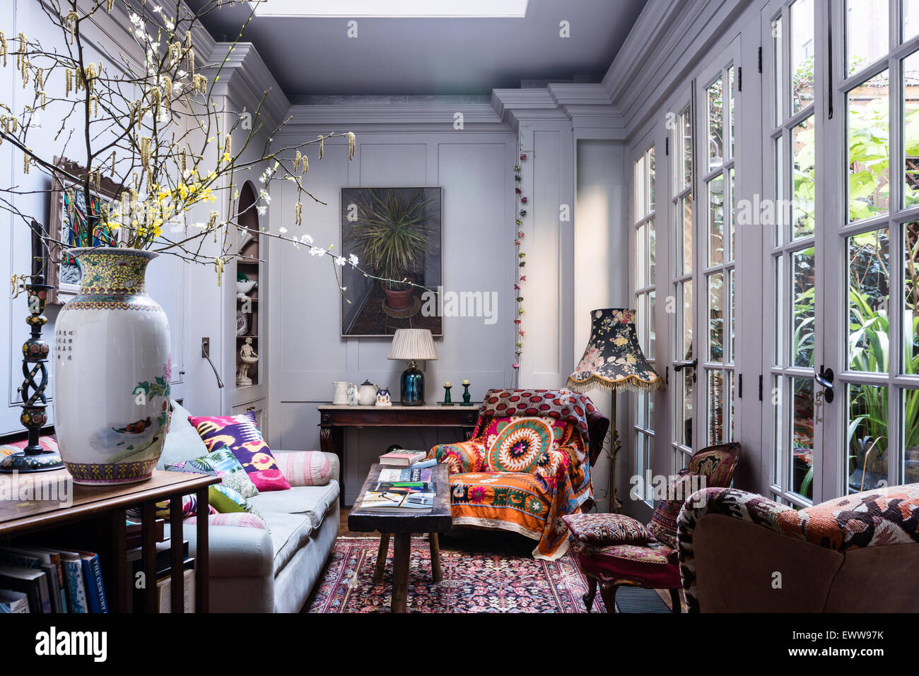 Georgianischen Stil Wohnzimmer mit rustikalen Eiche Sitzbank, usbekische Textilien und Perserteppich. Der gemusterte Lampenschirm ist von Schielen Li Stockfoto