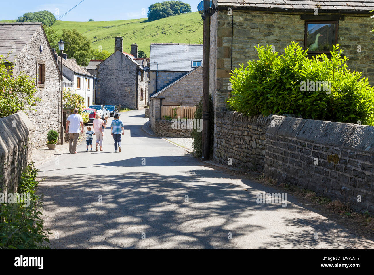 Menschen zu Fuß an einer ruhigen Straße in der englischen Dorf Castleton, Derbyshire, Peak District, England, Großbritannien im Sommer Stockfoto