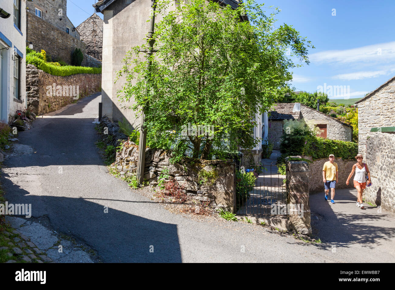 Menschen zu Fuß rund um den Peak District Dorfstraßen von Castleton im Sommer, Derbyshire, England, Großbritannien Stockfoto