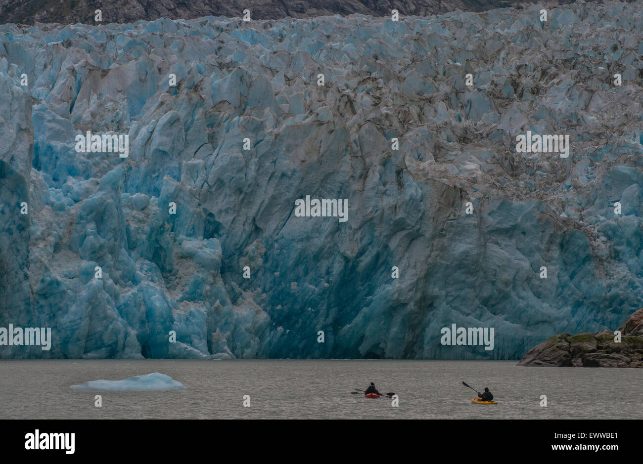 Kajakfahrer sind durch das zerklüftete Gesicht des Dawes-Gletschers in Endicott Arm Tracy Arm-Fords Terror Wildnis, südöstlichen Alaska, T in den Schatten gestellt Stockfoto