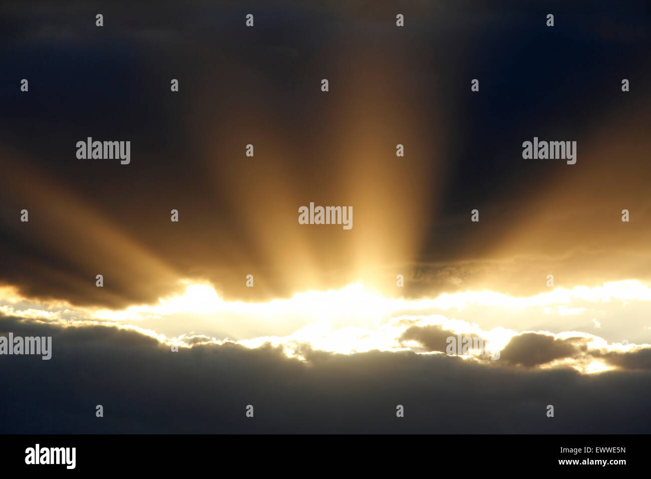 Ein Sonnenstrahl bricht durch dunkle Wolken. Stockfoto