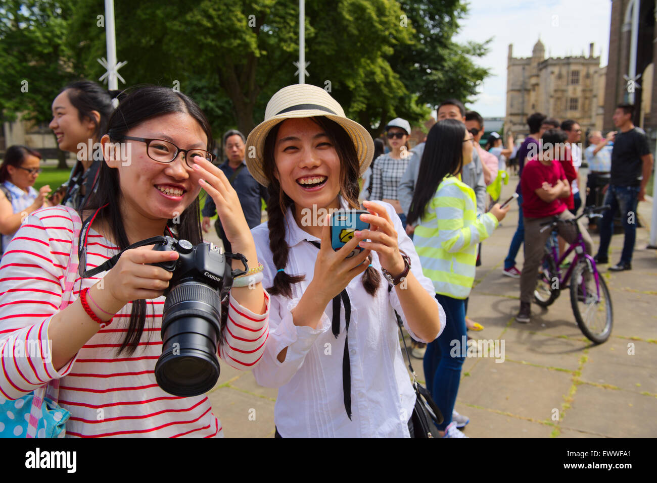 Zwei hübsche asiatische Frauen eine mit digitalen SLR-Kamera und andere mit Kamera-Handy vor Stockfoto